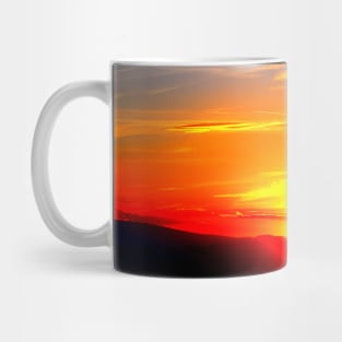 Dramatic sunset on the red-blue sky with the setting sun and clouds Mug